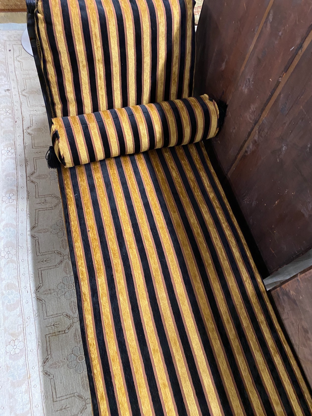 An Aesthetic period ebonised chaise longue, in the manner of E. W. Godwin, length 164cms, depth 61cms, height 75cms.